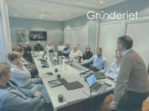 Fotografi av gründere som sitter rundt et bord i et møterom.
