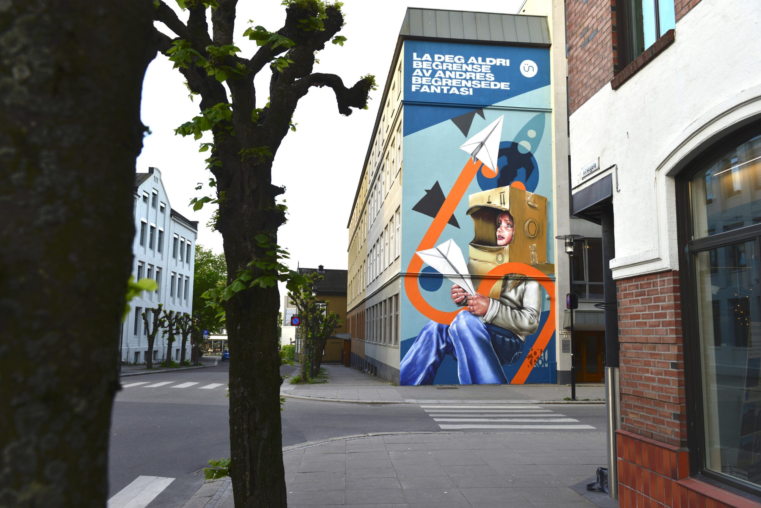 eggmaleri på et bygningshjørne ved Kirkegata i Sandefjord med teksten La deg aldri begrense av andres begrensede fantasi